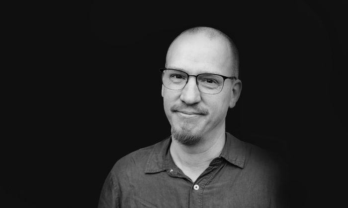 Ett svartvitt foto av Patrik Hagman mot svart bakgrund.