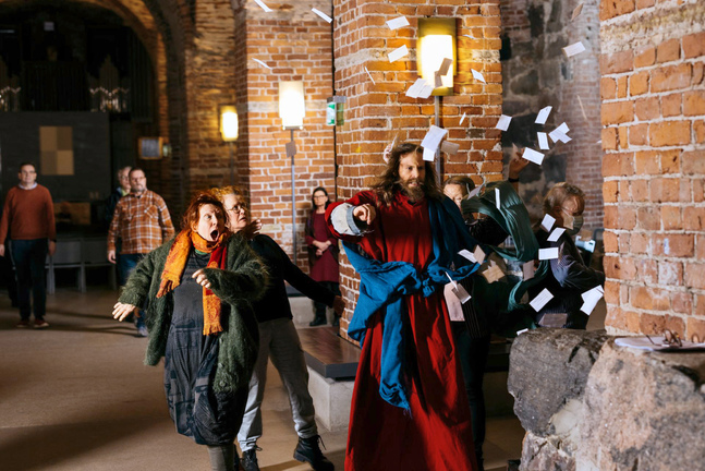 Harriet Kolehmainen, i orange halsduk, spelar rollen som djävul i passionsspelet Via Crucis. Till höger Jesus som i år spelas av skådespelaren Panu Haavisto. 
