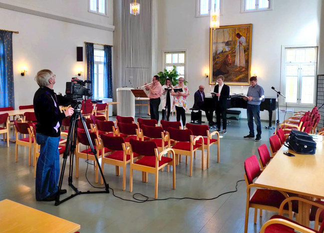 Sven-Erik Vesterback från Petalax-Bergö Lokal-tv-förening spelar in en sångstund i Petalax församlingshem.